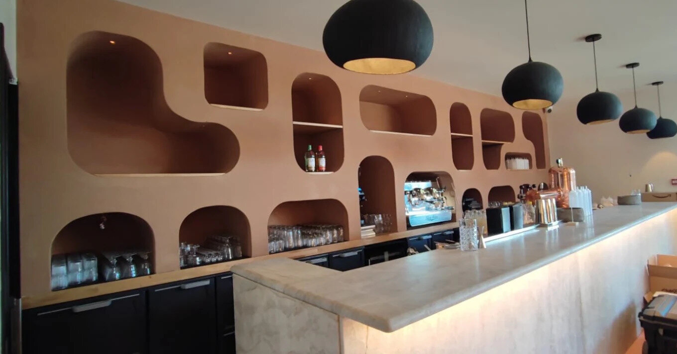 Mur courbe en placo décoratif avec niches à bouteilles réalisé par Rénovation Concept Sud